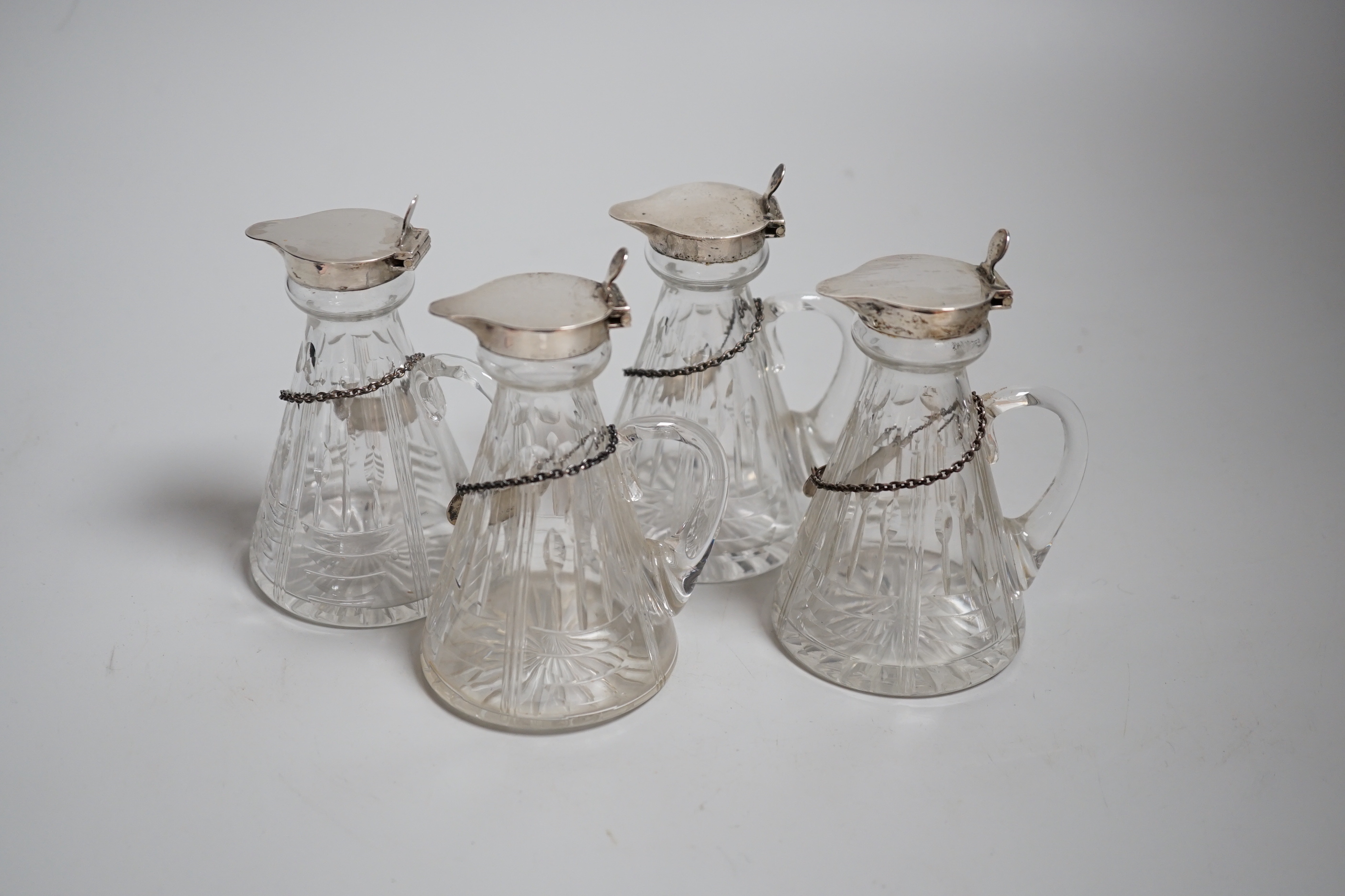 A set of four George VI silver mounted cut glass whisky noggins by Hukin & Heath, Birmingham, 1937, 11cm and four silver whisky labels, same date and maker.